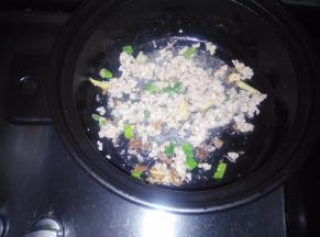 利用锅中的剩油，入葱姜蒜炒出香味。倒入肉馅儿翻炒至变色。