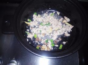 利用锅中的剩油，入葱姜蒜炒出香味。倒入肉馅儿翻炒至变色。