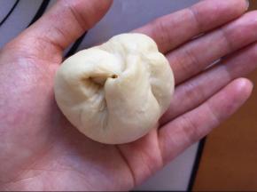 收口向上捏紧，收口向下放入膜具中