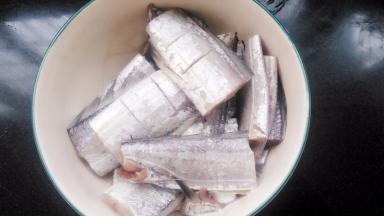 带鱼洗净，切段，用刀划上两刀以便入味。放入料酒和盐腌15分钟。