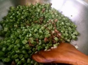 放入架豆王粒，抄到架豆王变色，倒入一碗清水盖上盖子中火，开锅之后放盐，炒几下，再盖上盖子中小火焖一会。收汁之后关火放味精。翻炒几下出锅。