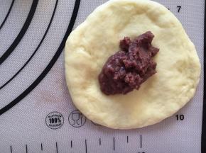 拿出一个面团压扁，放入红豆沙