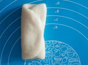 取一块面团，擀扁，左右向中间对折。