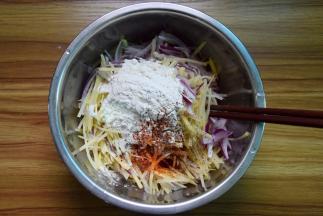 土豆丝、洋葱丝放大碗里，加面粉、盐、辣椒粉、黑胡椒粉