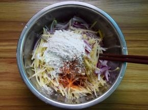 土豆丝、洋葱丝放大碗里，加面粉、盐、辣椒粉、黑胡椒粉