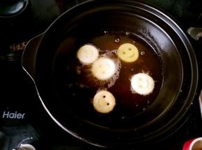 浅煲中油五六成热的时候一个个的把笑脸放进去，因为本来就是熟的所以炸的时间不用太长，金黄色就可以取出了。