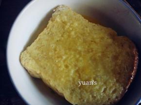 夹入芝士片的两面面包蘸满蛋液