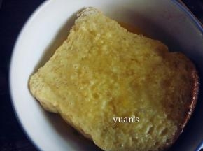夹入芝士片的两面面包蘸满蛋液