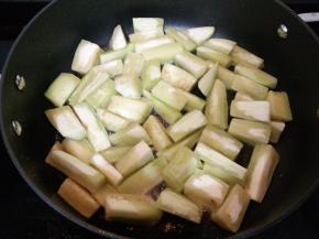 锅里倒入适量食用油烧五成热后倒入茄子炸至。