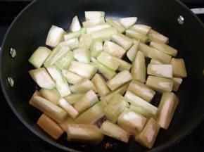 锅里倒入适量食用油烧五成热后倒入茄子炸至。