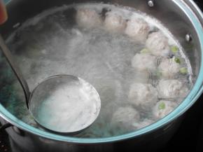 然后放入水中，待最后一个丸子挤完后，用勺子撇去锅中的浮沫