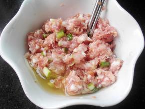 肉馅放碗中，调入料酒，盐，酱油，白胡椒粉，搅拌均匀；放入葱姜末，继续搅拌，放入一个鸡蛋的蛋清