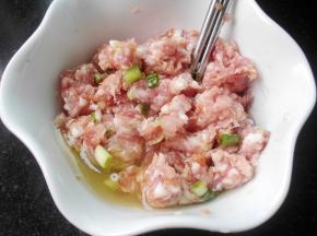 肉馅放碗中，调入料酒，盐，酱油，白胡椒粉，搅拌均匀；放入葱姜末，继续搅拌，放入一个鸡蛋的蛋清
