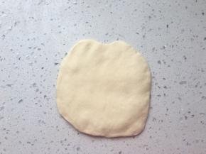 取一个90克面团擀圆，四周压薄