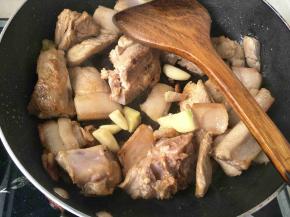 翻炒两分钟加入生姜，蒜头继续翻炒五分钟