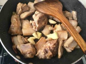 翻炒两分钟加入生姜，蒜头继续翻炒五分钟