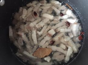 再将五花肉放入锅中，加入盖过五花肉的清水和八角、陈皮