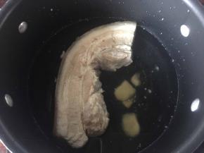 锅里煮开水后将五花肉放入锅中加入姜片焯熟