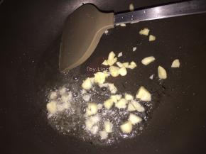 接着热锅，放适量食用油。倒入蒜瓣炒香