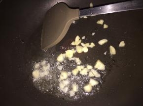 接着热锅，放适量食用油。倒入蒜瓣炒香