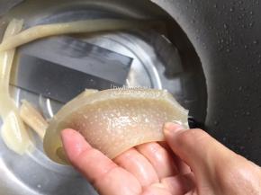 煮后的肉皮捞起放入冷水中冲洗干净。用刀刮去皮上的白色脂肪