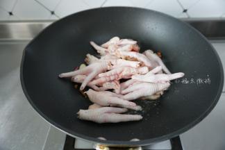 起油锅，姜片、蒜、干辣椒爆香，然后加入鸡爪翻炒
