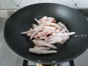 起油锅，姜片、蒜、干辣椒爆香，然后加入鸡爪翻炒