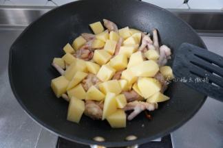 鸡爪变色后加入土豆翻炒一下
