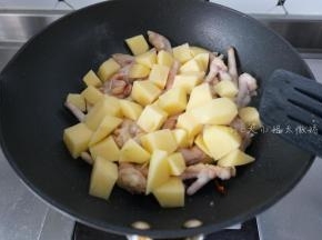 鸡爪变色后加入土豆翻炒一下