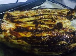 烤好的茄子取出划开，但不要划破，表面涂一层油，然后涂豆瓣酱