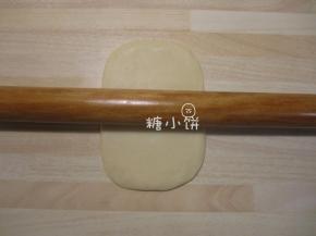 取一个油皮包好油酥的面剂子压扁，擀成矩形面片