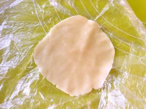 冰箱取出松弛好的面团，取15克一份，用擀面杖包裹上，擀成中间后西边薄的圆片