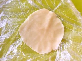 冰箱取出松弛好的面团，取15克一份，用擀面杖包裹上，擀成中间后西边薄的圆片