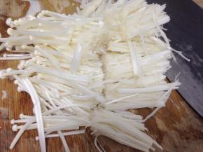 先把金针菇去根部洗净，切成两段备用。