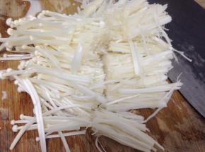 先把金针菇去根部洗净，切成两段备用。