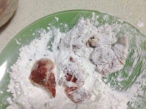 腌渍好的肉片沾上一层干淀粉，并抖去多余的淀粉。