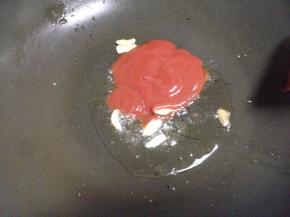 炒锅留底油，放入适量的姜片爆香后，放入番茄酱煸炒。