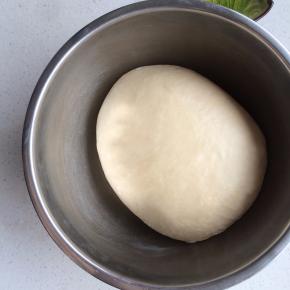 将面团整理滚圆，收光表面，加盖保鲜膜，室温26度左右，进行第一次发酵