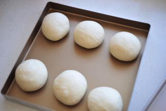面团倒入排气后，平均分成6倍，滚圆加保鲜膜，静置20分钟（我是直接两个金盘对盖的）