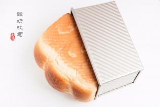 烘烤结束后，将吐司连模具一起震两下，震出热气后，侧倒于晾架上放凉