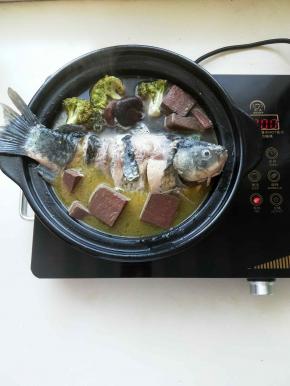 电陶炉大火转小火熬煮，用筷子将适量血块放在鱼身下面，防止鱼粘锅，