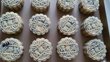 从模具内直接把月饼推到烤盘里，烤箱提前200度预热，放进烤箱进行烘烤