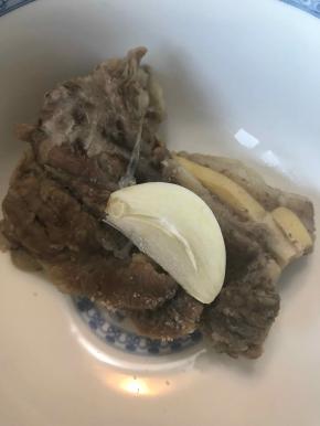 取一块羊肉，撒上些许盐，放上一片蒜（蒜是亮点，和蒜一起吃非常香），一口咬下去，太过瘾了。