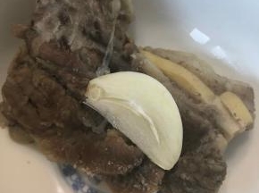 取一块羊肉，撒上些许盐，放上一片蒜（蒜是亮点，和蒜一起吃非常香），一口咬下去，太过瘾了。