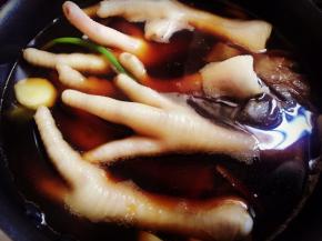 锅里的酱汁微微冒泡的时候加入鸡脚，盖上盖子。