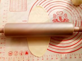 取一份面团，用阳晨金色不粘擀面杖擀成牛舌形。