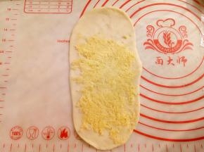 取15克椰蓉均匀铺在牛舌型面饼上。（如图留出1/5空余）