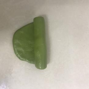 5 取一个酥皮面团，用手掌压一下，从中间向二头擀开，从上向下卷起。