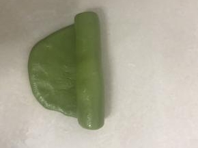 5 取一个酥皮面团，用手掌压一下，从中间向二头擀开，从上向下卷起。