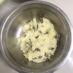 3 这时来做椰蓉馅，把室温软化的黄油加入白砂糖和一个全蛋液，用手动打蛋器搅打均匀至白砂糖溶化，加入椰蓉、葡萄干拌搅均匀，放入冰箱冷藏备用。